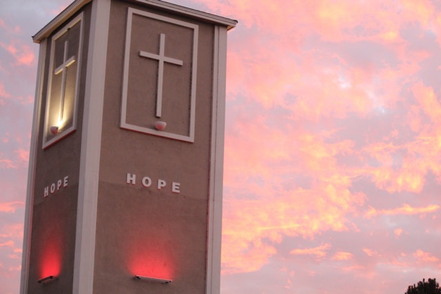 A tower with a cross during sunset